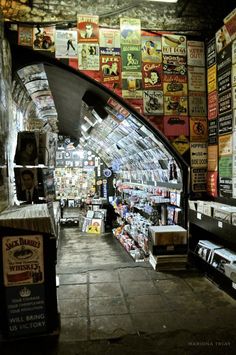 the inside of a book store with many books on shelves and posters hanging from the ceiling