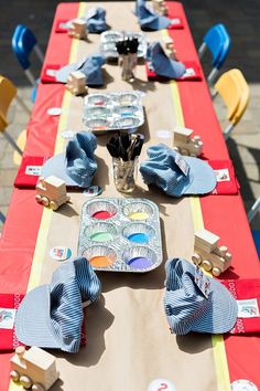 a long table is set up with plates and napkins