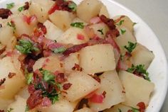 a white plate topped with potatoes and bacon