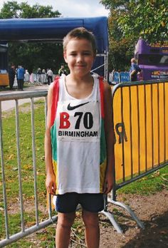 a young boy is standing in front of a barricade with his name on it