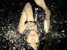 a woman laying on her back in the water with bubbles all over her body and head