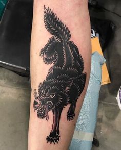 a black and white tattoo on the leg of a person with a wolf head design