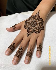 a woman's hand with henna tattoos on it