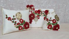 two white pillows with red flowers on them