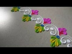 an intricately decorated table with flowers and swirls on the edge, is shown