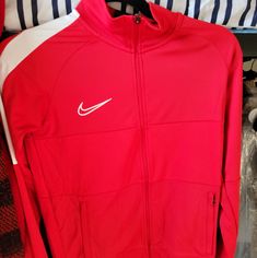 Nike Track Jacket Sporty University Red Outerwear For Fall, University Red Winter Sports Outerwear, Red Track Jacket For Outdoor Winter Activities, Red Spring Track Jacket For Sports, Nike Red Sporty Outerwear, University Red Hooded Outerwear For Fall, Red Outerwear For Sports In Fall, Red Nike Casual Track Jacket, Red Hooded Track Jacket For Fall