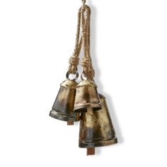 two bells hanging from a rope on a white wall