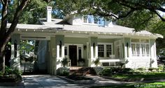 a white house with trees and grass around it