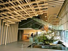 an indoor atrium with glass railings and wooden slats on the ceiling above it