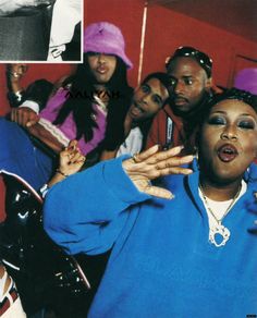 a group of people posing for a photo in front of a red wall and wearing purple hats