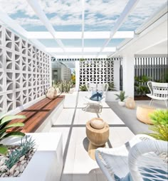 an outdoor patio with white furniture and plants