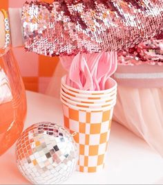 there is a vase with pink flowers in it next to a disco ball and other decorations