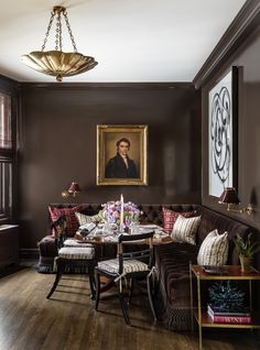 a living room filled with furniture and a painting hanging on the wall over a wooden floor