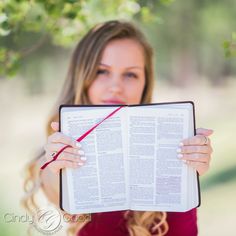 a woman holding an open book in front of her face