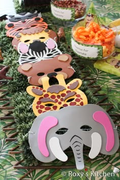 an elephant, giraffe and zebra masks are on the table