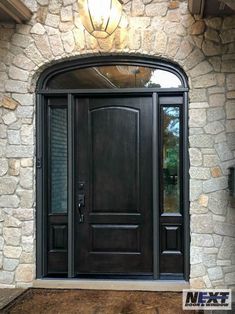 a black front door with two sidelights and a glass window on the outside of it