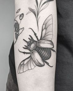 a black and white photo of a bee on the arm