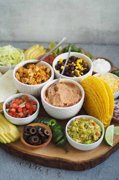 a platter filled with tacos, guacamole, and other condiments