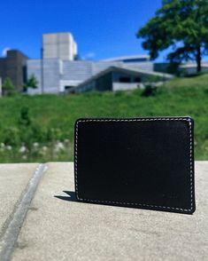 Slimmy R1S1 (68mm) in the black colorway with white stitching eliminates excess layers for maximum slimness (4mm) and is designed to perfectly fit credit cards and your ID. The center pocket provides fast access to cash and cards. Side slots accommodate fewer used cards and create tension to keep things tight. Black with white stitching colorway Open 1-Pocket Design Made for front pocket carry Minimalist Everyday Carry Sized for credit cards and ID. Capacity: 7 Money Cards/ID, 7 Bills, 5 Receipt Modern Black Wallet For Daily Use, Black Rectangular Card Holder With Phone Sleeve, Modern Black Wallets For Business, Modern Black Card Holder With Interior Slots, Modern Black Business Wallets, Modern Black Rectangular Card Holder, Black Rfid Blocking Wallet For Business, Modern Black Card Holder With Rfid Blocking, Modern Black Rfid Blocking Card Holder