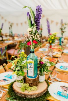 the table is set with flowers and bottles