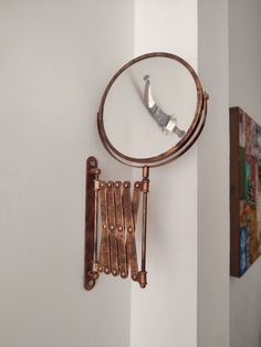 a mirror hanging on the side of a wall with keys attached to it and a key holder in front of it