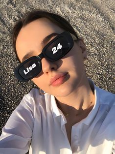 a woman wearing sunglasses with the number 24 printed on her face and one eye closed