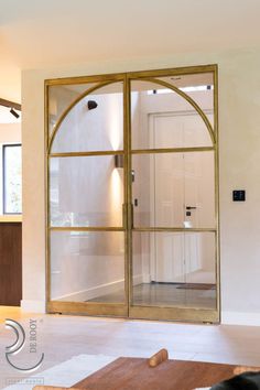 an open glass door in the middle of a room with a rug on the floor