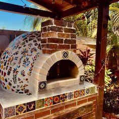 an outdoor pizza oven with colorful tiles on it