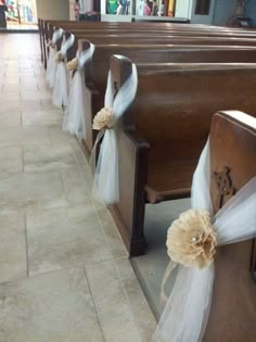 two rows of pews decorated with white tulle and bows