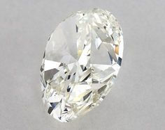 an oval cut diamond sitting on top of a white surface with no other diamonds around it