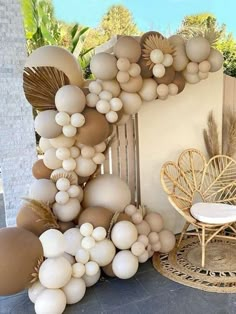 a bunch of balloons that are in the shape of shells on a table next to a chair