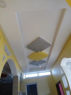 the ceiling is painted yellow and white with an unusual design on it's side