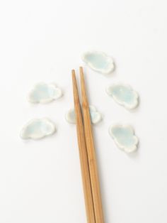 chopsticks and small clouds on a white surface