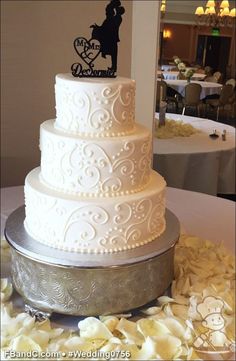 a three tiered white wedding cake sitting on top of a table