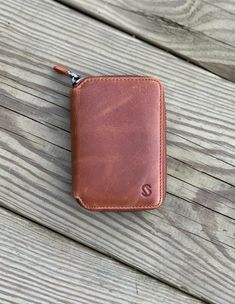 a brown leather wallet sitting on top of a wooden table