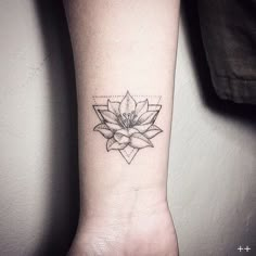 a black and white photo of a flower tattoo on the left arm with an arrow in the middle