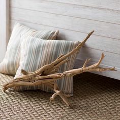 driftwood sticks sticking out of the bottom of a bed with two pillows on it