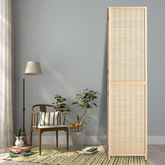 an empty room with a chair, lamp and bamboo screen on the floor in front of it