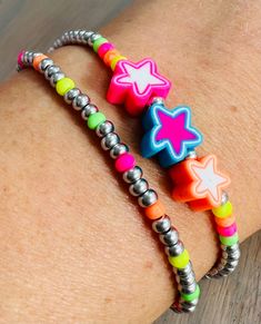 The Beadbound Jewellery💜 Troll inspired party bracelet set is a fun and bright accessory for your wrist. Made by hand, the bracelet set contains a a silver and neon seed bead bracelet and a silver seed bead bracelet, which is finished with 3 colourful star charm beads placed between neon beads. Both compliment each other nicely. Please see the star charms available on photo 5 so you can choose which 3 charms you would like for your bracelet. Once you have placed your order I will DM you to get your choice. The beads are threaded on to elastic string so the bracelets will stretch to fit your wrist, but while care is taken to secure the beads, please don't overstretch them to avoid damage. Different size bracelet lengths are available so please choose your size when ordering. Due to the bra Trendy Silver Friendship Bracelets With Round Beads, Playful Party Bracelets With Colorful Beads, Playful Colorful Beads Bracelets For Party, Playful Colorful Beaded Party Bracelets, Trendy Neon Bracelets As Gift, Trendy Silver Friendship Bracelets With Letter Beads, Trendy Neon Bracelets For Gifts, Party Multicolor Friendship Bracelets With Letter Beads, Multicolor Letter Beads Friendship Bracelets For Party