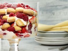 a trifle with strawberries, bananas and whipped cream in a glass dish on a table