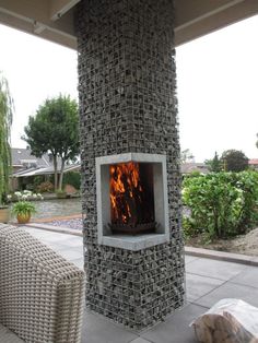 an outdoor fireplace in the middle of a patio