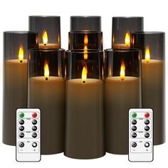 six lit candles with remote controls in front of them