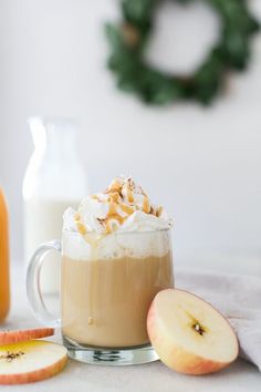 there is a cup of coffee with whipped cream and apples