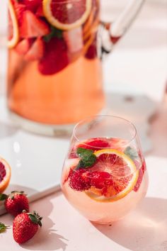 a pitcher of water with strawberries and orange slices