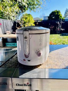 an electric pressure cooker sitting on top of a table in front of a house