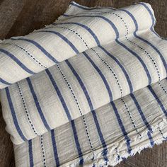 three blue and white striped linens stacked on top of each other