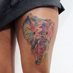 an elephant tattoo on the leg of a woman's thigh, with watercolors