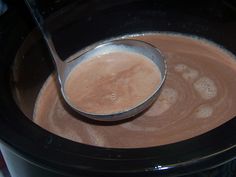 a spoon in a crock pot filled with hot chocolate