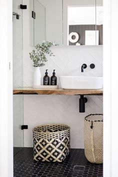 a bathroom with a sink, mirror and basket