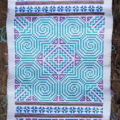 a close up of a piece of cloth with blue and purple designs on the fabric